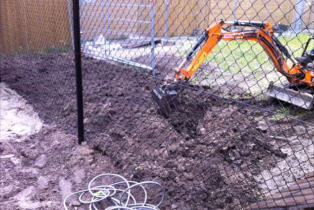 omspitten grond in achtertuin  met minigraver door een poortje van 100cm onze machine is 84 cm breed